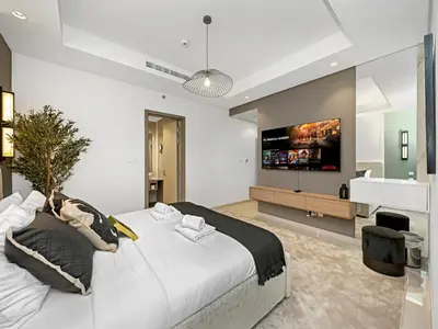 a bedroom with a large white bed and a television at WonderfulStay at Paramount Residences - Highest Infinity Pool - Burj Khalifa View - Brand New Luxury Apartments in Dubai