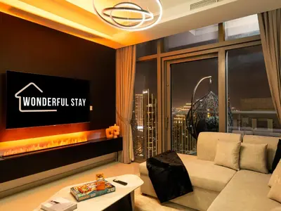 a living room with a couch and a tv at WonderfulStay at Paramount Residences - Highest Infinity Pool - Burj Khalifa View - Brand New Luxury Apartments in Dubai