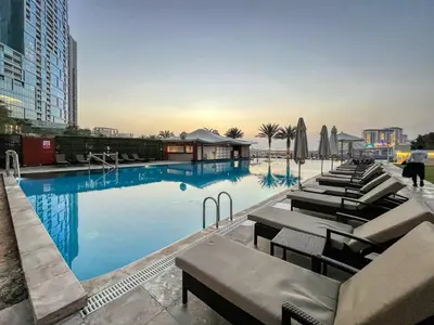 a large swimming pool with lounge chairs and umbrellas at Artistic Retreat in JBR with Private Beach Access in Dubai