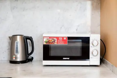 a microwave sitting on a counter next to a coffee pot at Palm Jumeirah Studio Sea View Royal Amwaj in Dubai