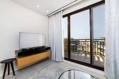 a living room with a tv and a large window at Palm Jumeirah Studio Sea View Royal Amwaj in Dubai