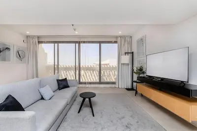 a living room with a couch and a flat screen tv at Palm Jumeirah Sea View 1Bdr in Dubai