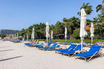 a row of lounge chairs and umbrellas on a beach at Palm Jumeirah Sea View 1Bdr in Dubai