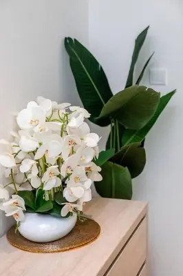 a white vase filled with white flowers on a table at Private Beach Palm Jumeirah Studio high floor in Dubai