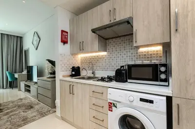 a kitchen with a washing machine and a microwave at Private Beach Palm Jumeirah Studio high floor in Dubai