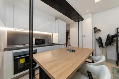 a kitchen with a wooden table in a room at Downtown Studio Sterling WEST in Dubai