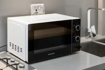 a white and black microwave sitting on a counter at Downtown Studio Sterling WEST in Dubai