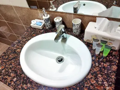 a white sink in a bathroom with a counter top at Elegant Fresh 1BR with Heated Pool, just steps from Mall, Restaurants & Fitness center in Dubai