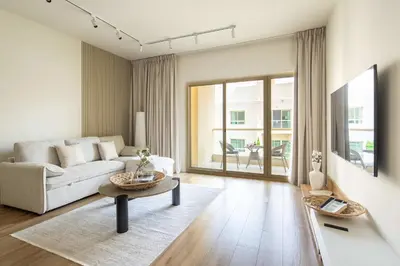 a living room with a couch and a table at Frank Porter - Al Dhafrah 2 in Dubai