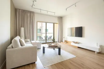 a living room with a couch and a table at Frank Porter - Al Dhafrah 2 in Dubai
