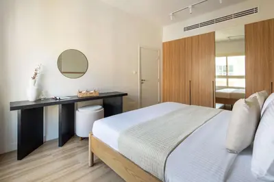 a bedroom with a bed and a desk with a mirror at Frank Porter - Al Dhafrah 2 in Dubai