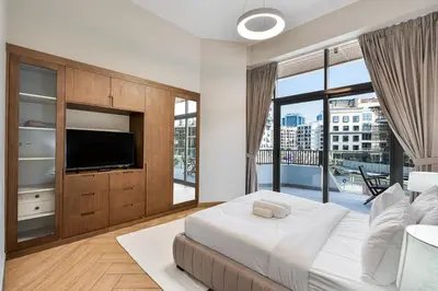 a bedroom with a large bed and a television at Modern 2 BR Apartment near Dubai Butterfly Garden in Dubai