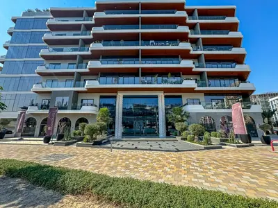 a large apartment building with a courtyard in front of it at Modern 2 BR Apartment near Dubai Butterfly Garden in Dubai
