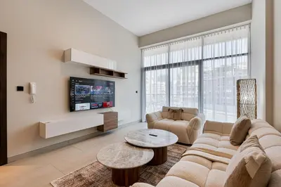 a living room with a couch and a table at Modern 2 BR Apartment near Dubai Butterfly Garden in Dubai