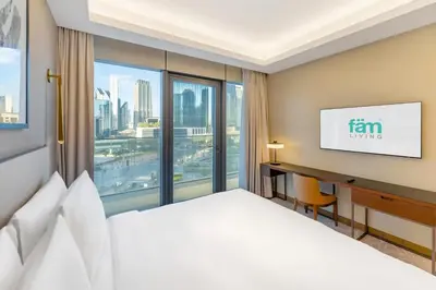 a hotel room with a bed and a desk and a window at FAM Living - Address Residences Opera - Luxurious 2Bed in Dubai