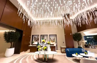a lobby with a chandelier and tables and chairs at FAM Living - Address Residences Opera - Luxurious 2Bed in Dubai