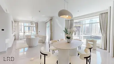 a white living room with a table and chairs at Luxurious Apartment with Marina Views in Dubai
