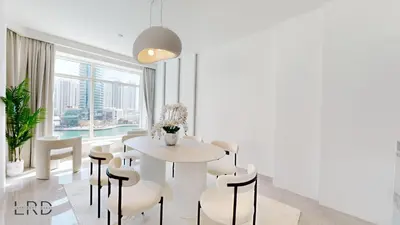 a white dining room with a table and chairs at Luxurious Apartment with Marina Views in Dubai