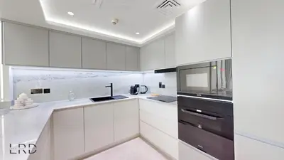 a white kitchen with white cabinets and a microwave at Luxurious Apartment with Marina Views in Dubai
