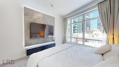 a bedroom with a large bed and a large window at Luxurious Apartment with Marina Views in Dubai