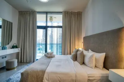 a bedroom with a large bed with a large window at 1-Bedroom in Merano Tower, Business Bay with City Views in Dubai