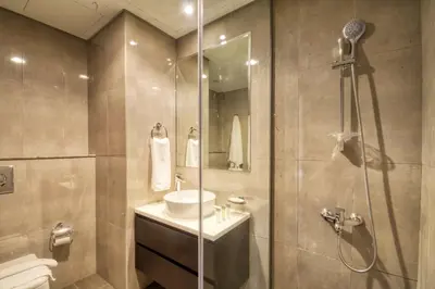a bathroom with a shower and a sink and a toilet at 1-Bedroom in Merano Tower, Business Bay with City Views in Dubai