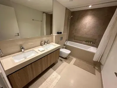 a bathroom with two sinks and a tub and a toilet at Your Dubai Home in Dubai