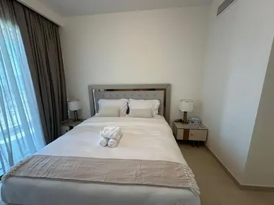 a bedroom with a bed with two towels on it at Your Dubai Home in Dubai