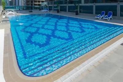 a large swimming pool with blue water in a building at Canal View, 1BR, Terrace I Gym, Pool, Parking in Dubai