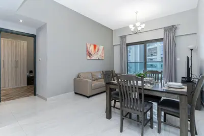 a dining room and living room with a table and chairs at Canal View, 1BR, Terrace I Gym, Pool, Parking in Dubai