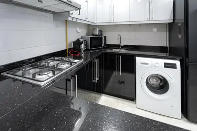 a kitchen with a washing machine and a washer at Canal View, 1BR, Terrace I Gym, Pool, Parking in Dubai