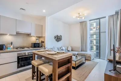 a kitchen and living room with a table and chairs at STAY BY LATINEM Luxury 1BR Holiday Home CVR B2303 near Burj Khalifa in Dubai
