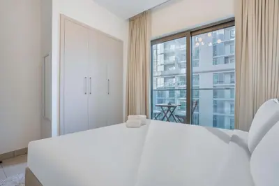 a bedroom with a white bed and a large window at STAY BY LATINEM Luxury 1BR Holiday Home CVR B2303 near Burj Khalifa in Dubai