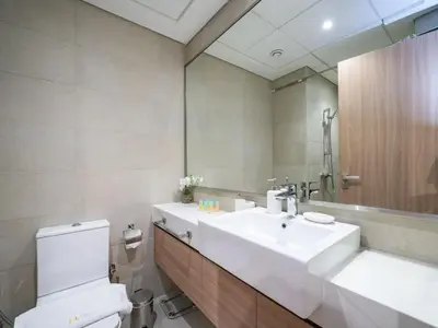 a bathroom with a sink and a toilet and a mirror at Chic Studio Azizi Riviera Retreat with City Views in Dubai