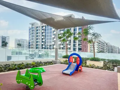 two childrens chairs on a patio with a view of a building at Chic Studio Azizi Riviera Retreat with City Views in Dubai
