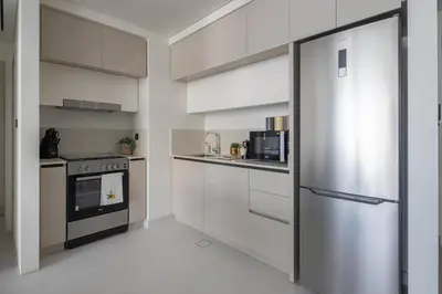 a kitchen with white cabinets and a stainless steel refrigerator at Frank Porter - Marina Vista 2 in Dubai