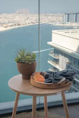 a table with a bowl of fruit and a plant on it at Frank Porter - Marina Vista 2 in Dubai