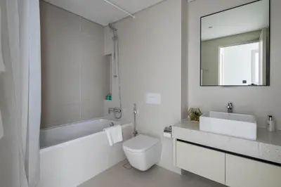 a white bathroom with a toilet and a sink at Frank Porter - Marina Vista 2 in Dubai