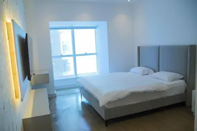 a white bedroom with a bed and a window at Stunning SeaView Elite Residence Dubai Marina in Dubai