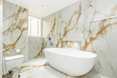 a bathroom with a large white tub and marble walls at Luxury 4 Bed apartment in Murjan, JBR in Dubai