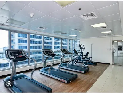 a gym with rows of cardio equipment in a building at Elegant 1BR Apartment in Dubai LuxuryStay in Dubai