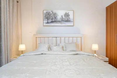 a bedroom with a large white bed with two lamps at Elegant 1BR Apartment in Dubai LuxuryStay in Dubai
