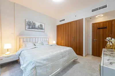 a bedroom with a large bed and a wooden closet at Elegant 1BR Apartment in Dubai LuxuryStay in Dubai