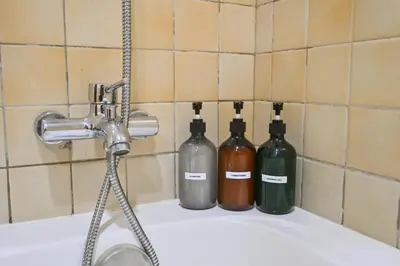 three wine bottles sitting on top of a bath tub at 7 Beds - JBR Beach 3 min walk in Dubai