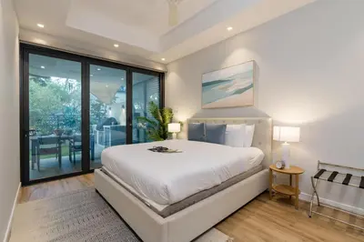 a bedroom with a large white bed and sliding glass doors at Lovey Unique Property- Garden and Barbeque Area in Dubai