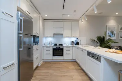a kitchen with white cabinets and a counter top at Lovey Unique Property- Garden and Barbeque Area in Dubai