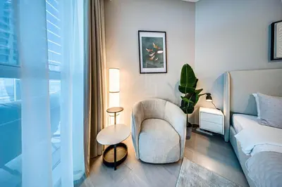 a living room with a chair and a bed at Wonderful New Studio in Missoni Business Bay in Dubai