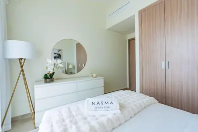 a bedroom with a white bed and a mirror at Nasma - Modern 3BR Oasis with Balcony in Azizi Riviera in Dubai