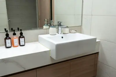 a bathroom with a white sink and a mirror at Nasma - Modern 3BR Oasis with Balcony in Azizi Riviera in Dubai