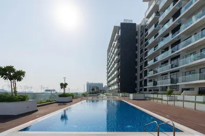 a swimming pool in front of a building at Nasma - Modern 3BR Oasis with Balcony in Azizi Riviera in Dubai